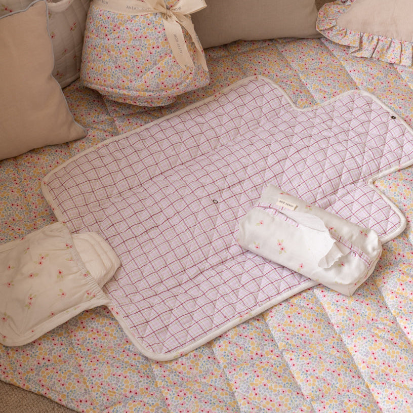 Baby quilt with pillows on a floral-patterned blanket