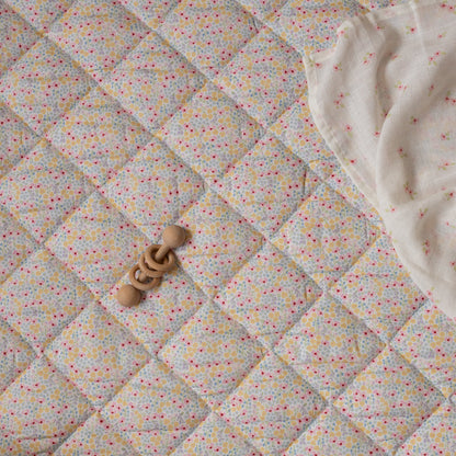 Quilted fabric with a geometric pattern and wooden rings on top