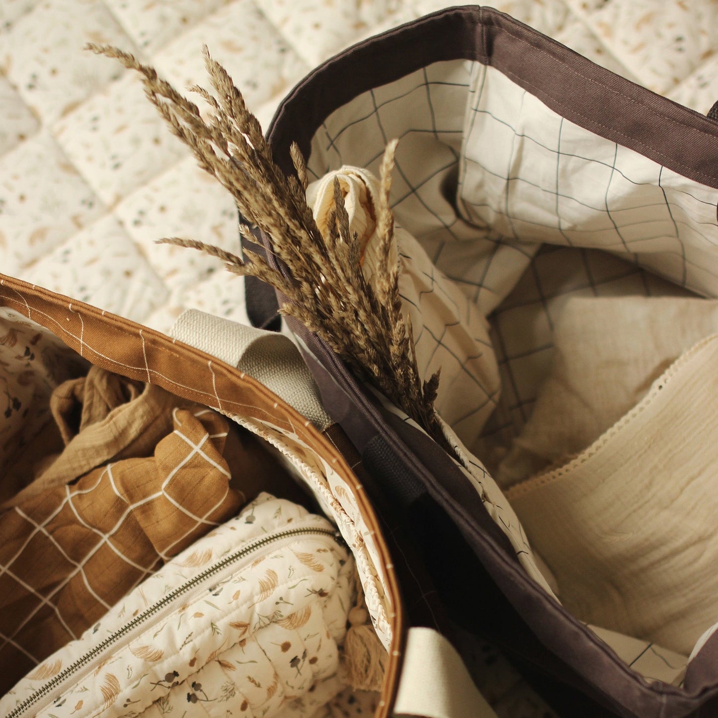 Close-up of a textured fabric with a brown border and dried plants.