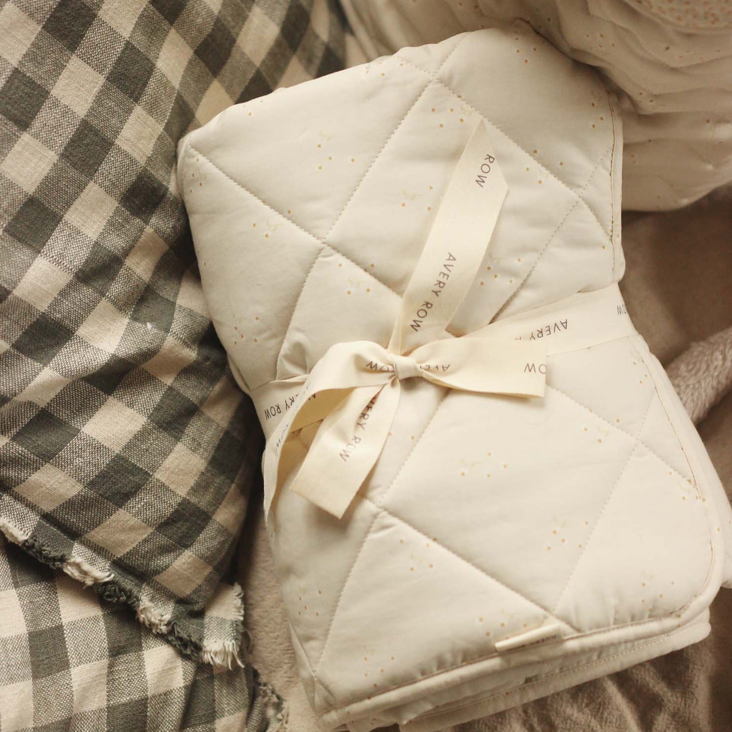 Folded quilt with a ribbon and tag on a checkered fabric background