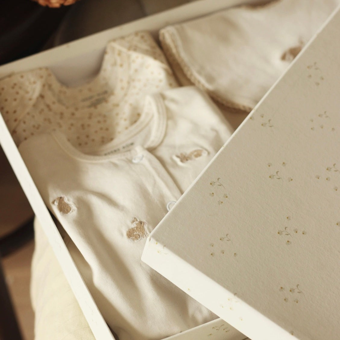 Beige baby outfit with floral patterns in a box