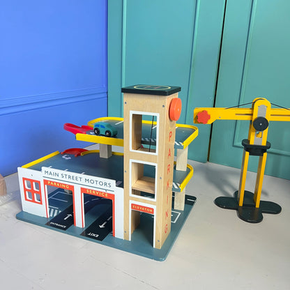 Toy car garage set with lift and cars on a blue and green background