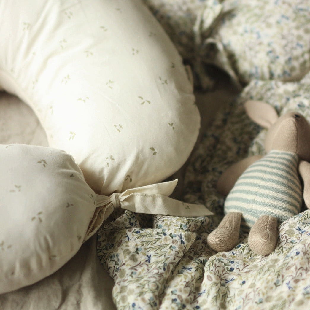 Floral bedding with a plush toy and decorative pillows