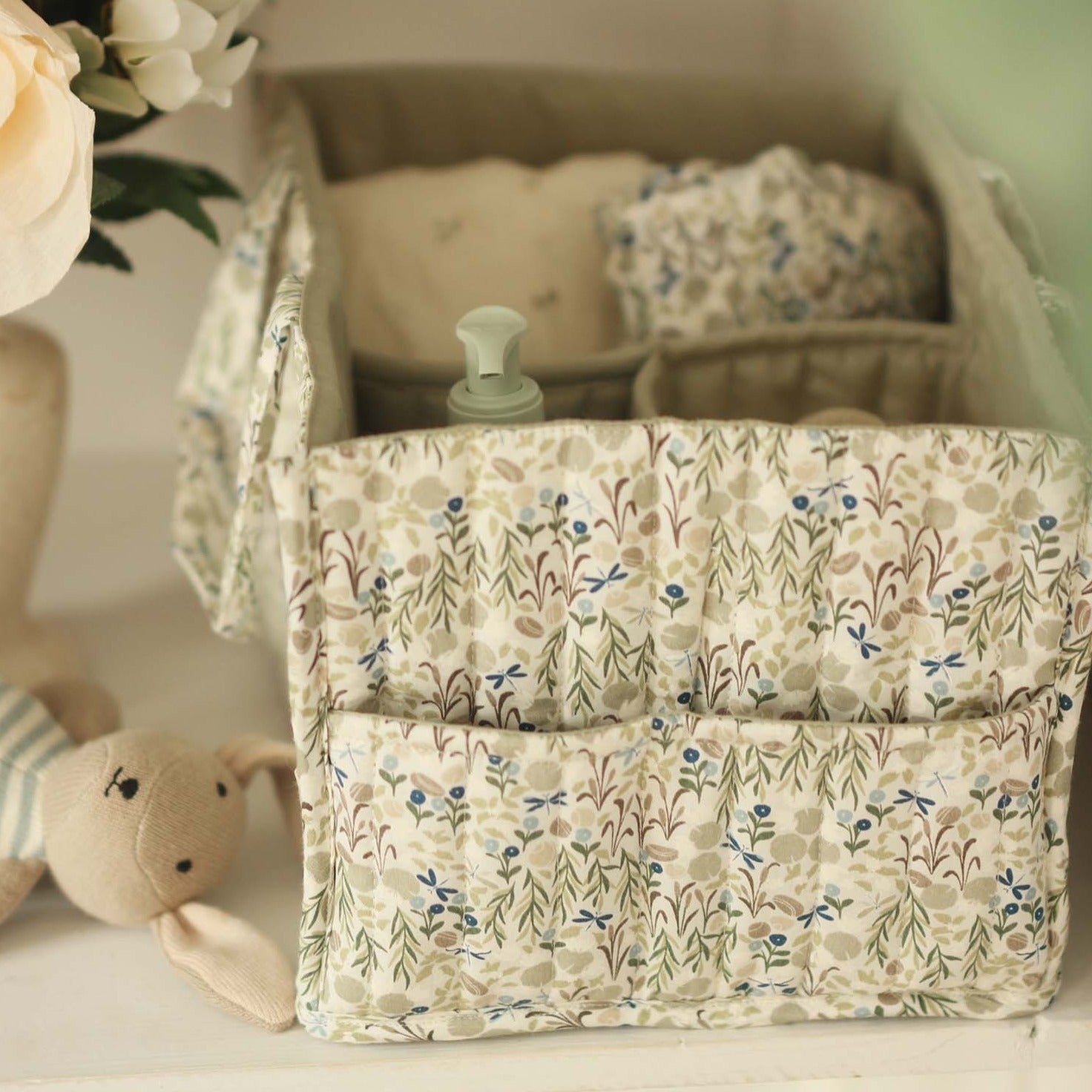 Floral-patterned storage basket with baby items on a light surface