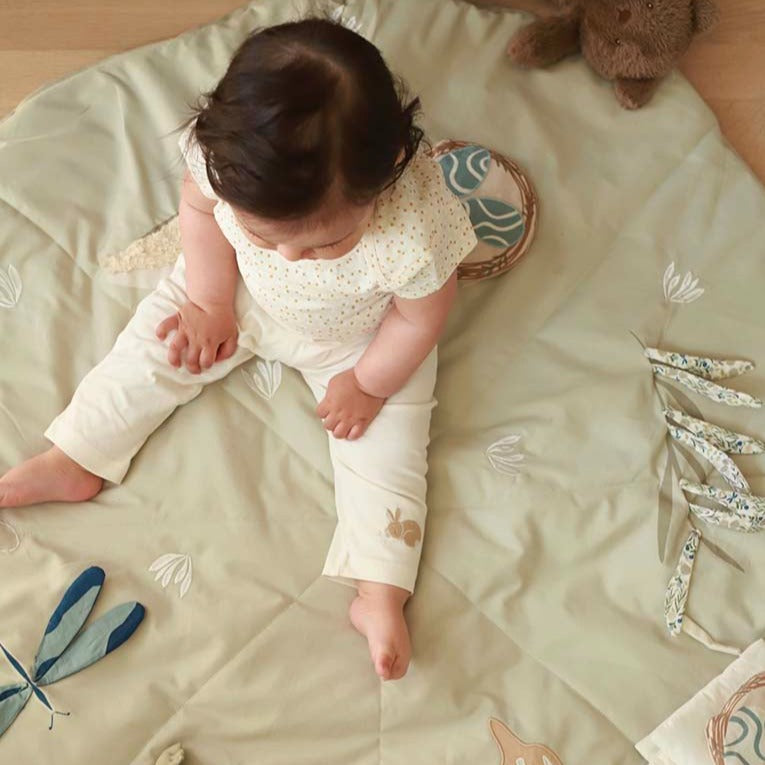 Baby sitting on a soft surface with floral patterns