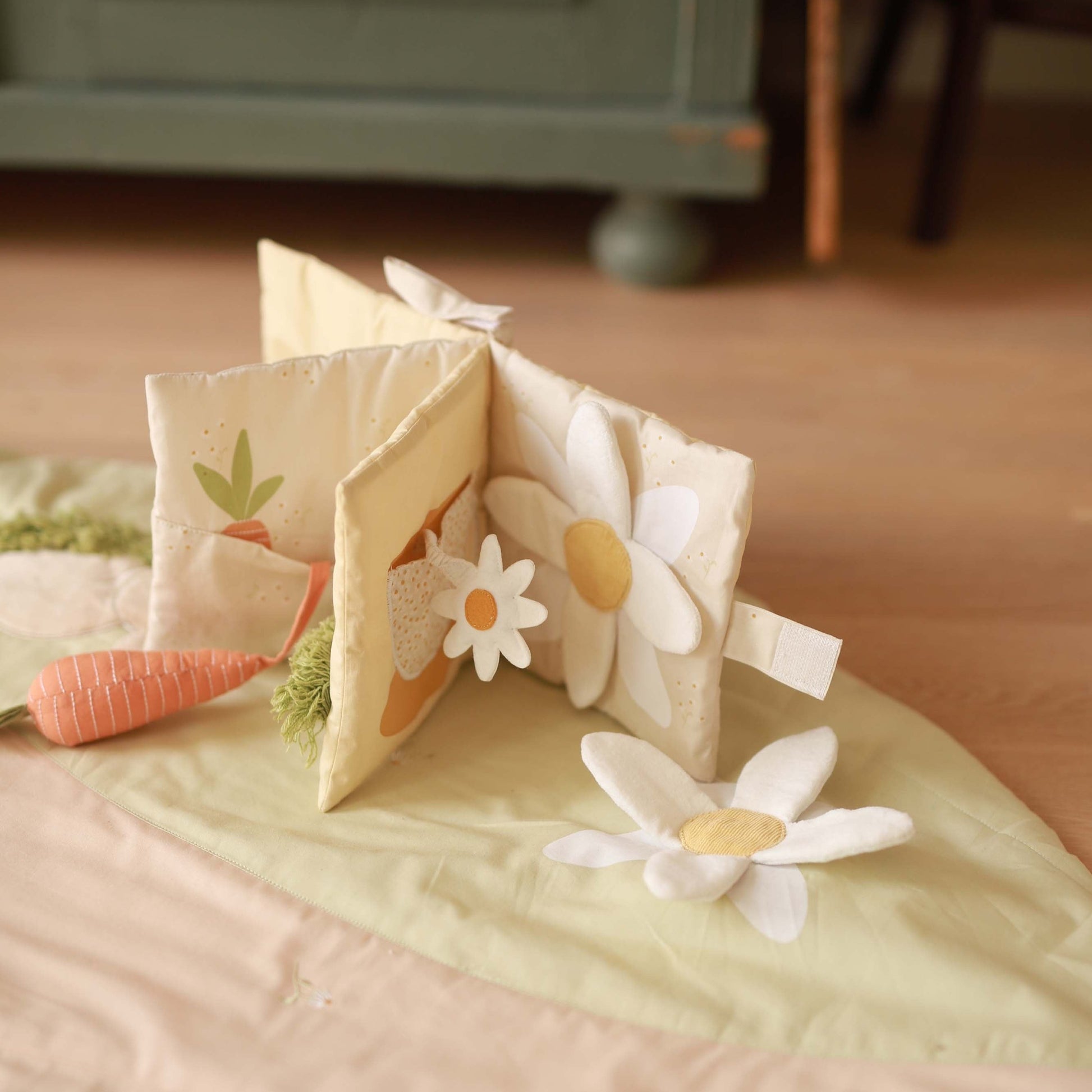 Children's soft book with floral designs on a bed