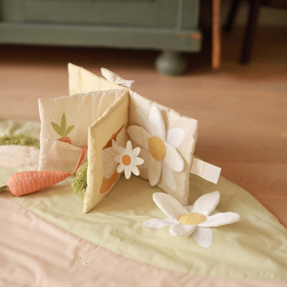 Children's soft book with floral designs on a bed