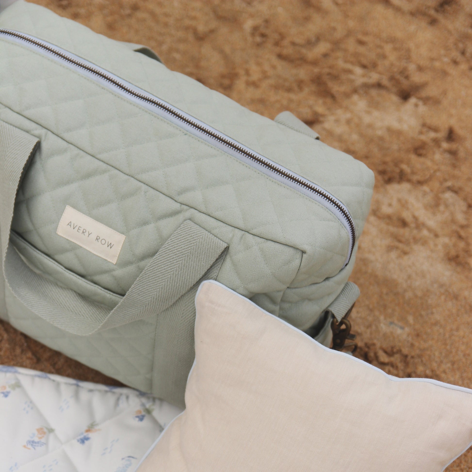Light green baby bag with 'Avery Row' label on a textured surface