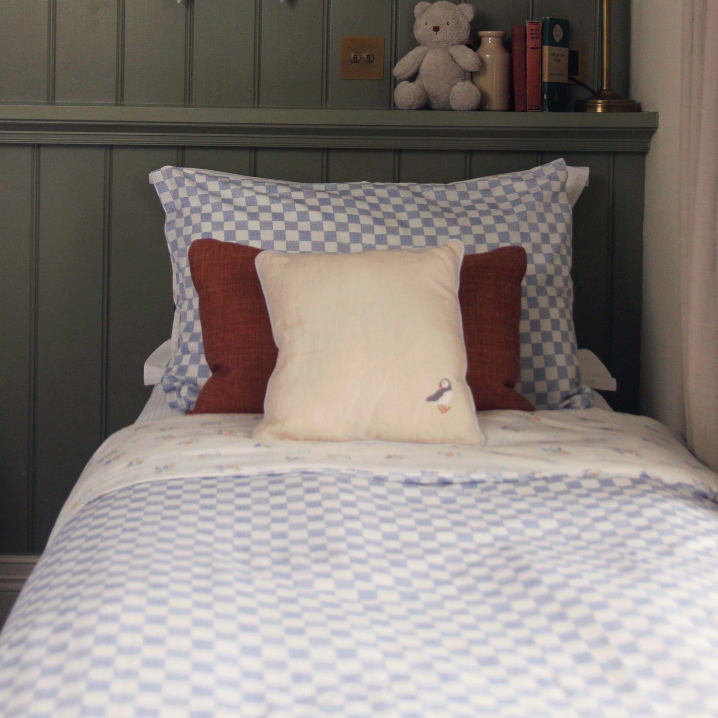 Bed with checkered bedding and pillows in a bedroom setting