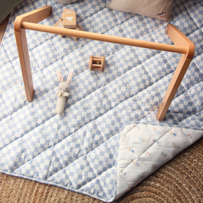 Checkered quilted mat with wooden frame on a checkered floor