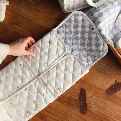 Quilted pad with butterfly pattern on a wooden surface