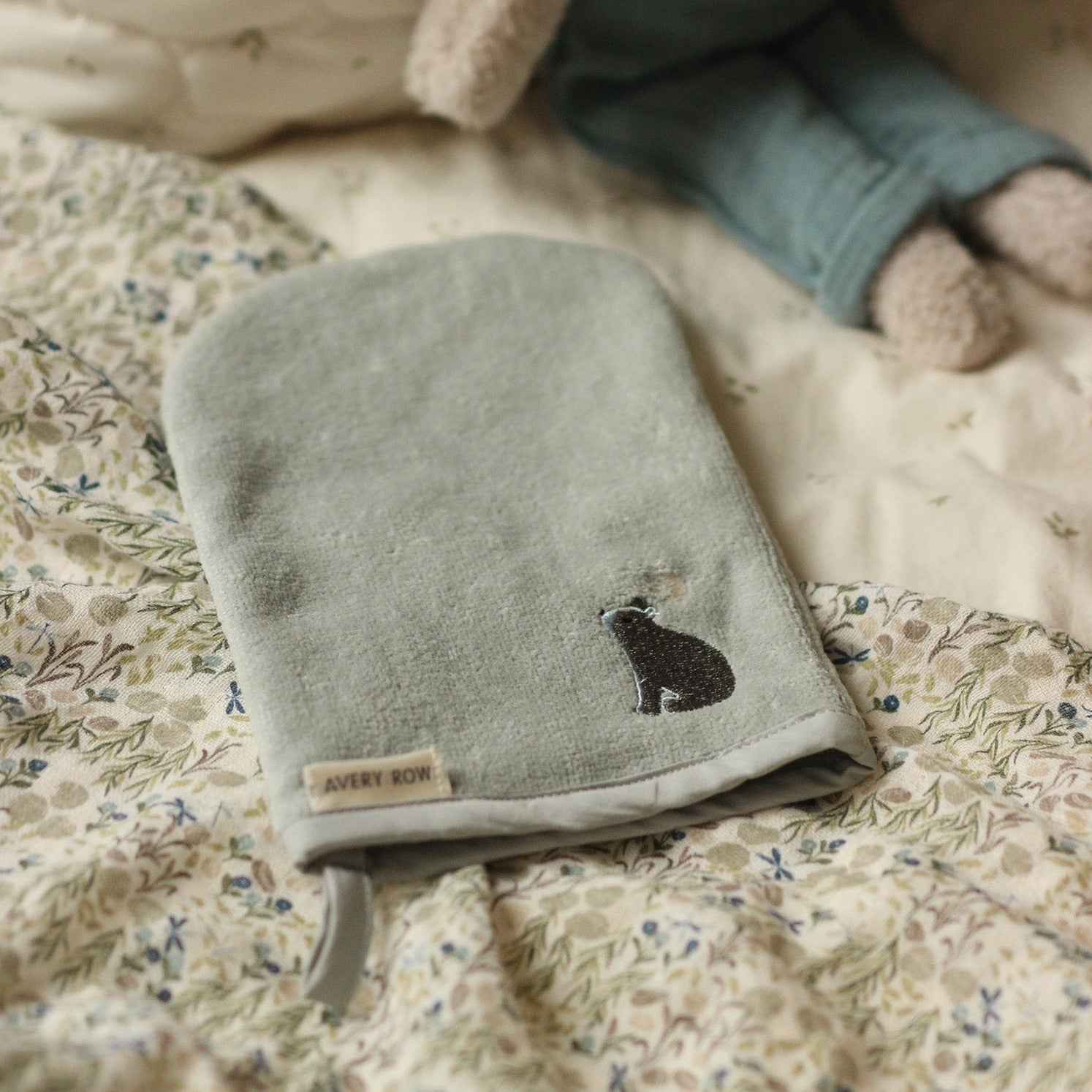 Gray pouch with a cat design on a floral blanket