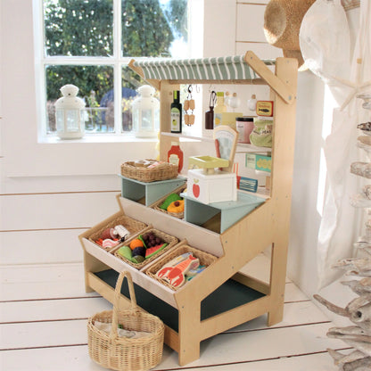 Children's play kitchen set with various toys and items on a wooden floor.
