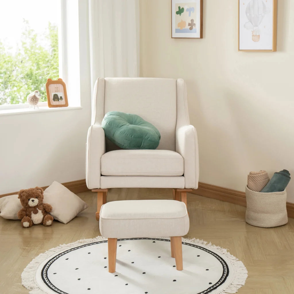 White armchair with a green cushion in a room with a teddy bear and a rug.