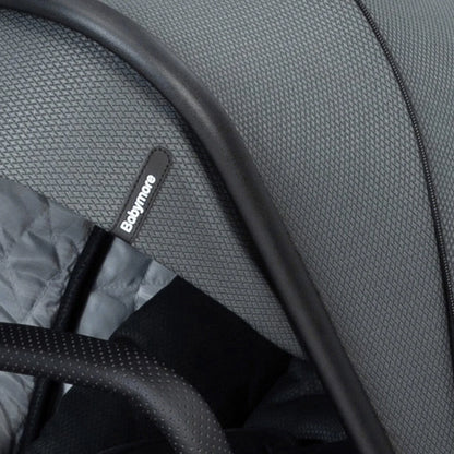 Close-up of a gray stroller seat with a visible brand label.