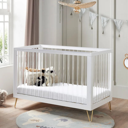 White crib with toys in a nursery setting