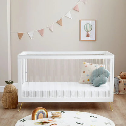 White crib in a nursery with decorative elements and toys.