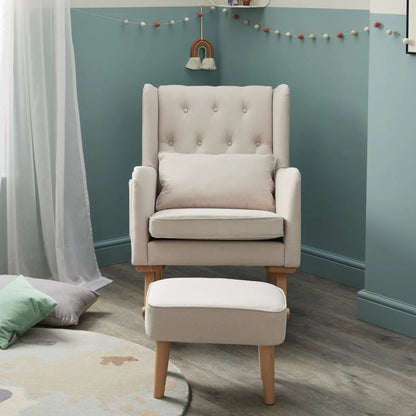 Beige armchair with matching ottoman against a teal wall