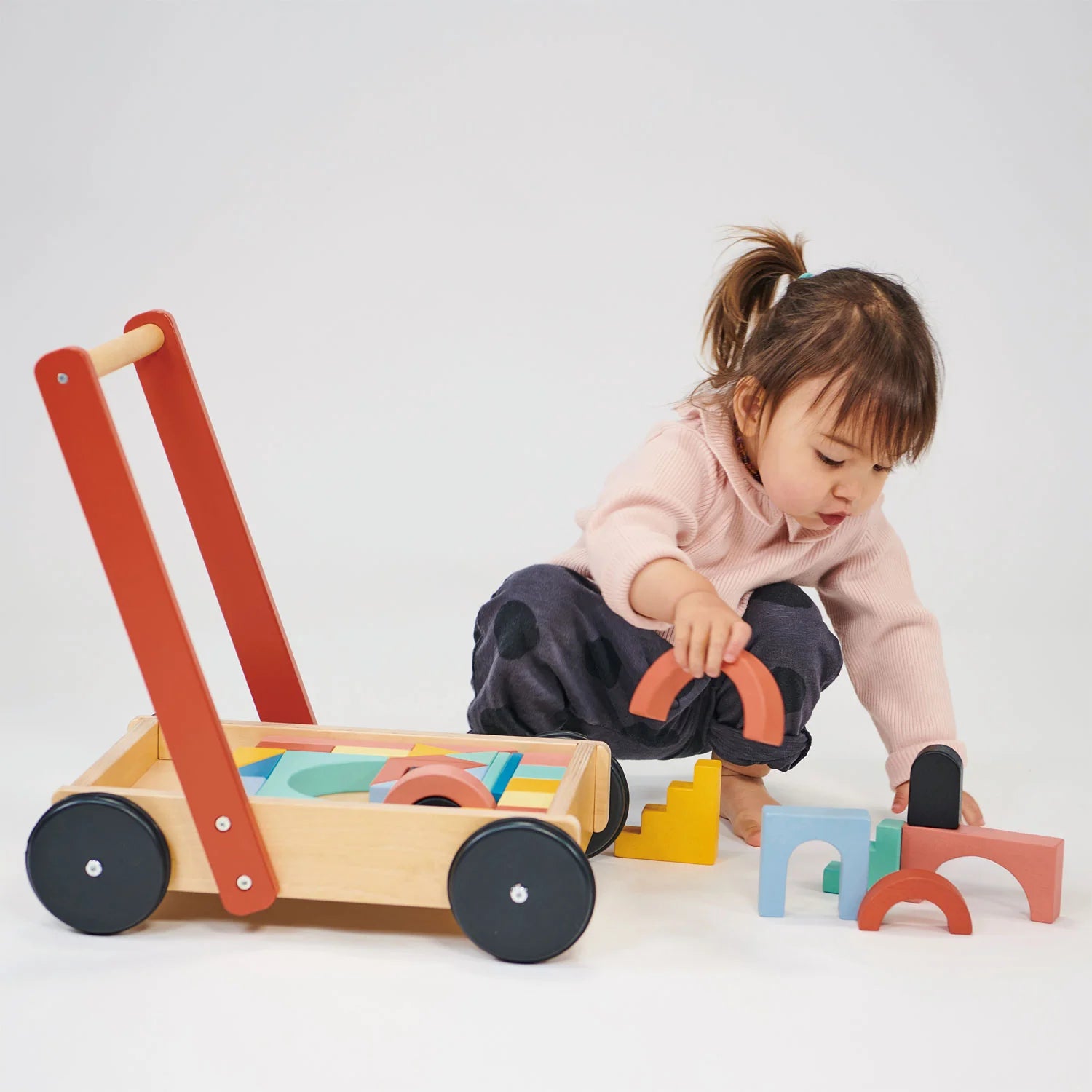 Child playing with a wooden toy on a white background