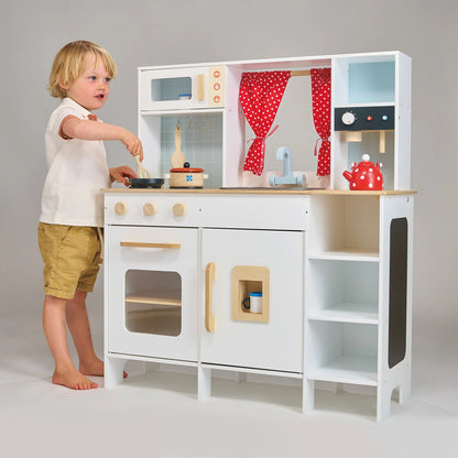 Child playing with a toy kitchen set on a plain background