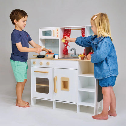 Two children playing with a toy kitchen