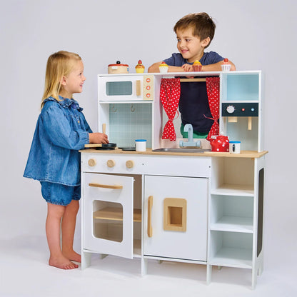 Two children playing with a toy kitchen set on a white background