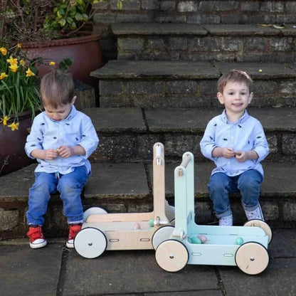 Two children playing with a wooden toy on stone steps outdoors.