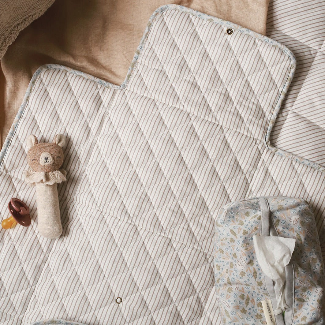 Quilted baby blanket with toys on a soft surface