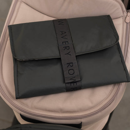 Black pouch with 'Avery Row' branding on a beige bag