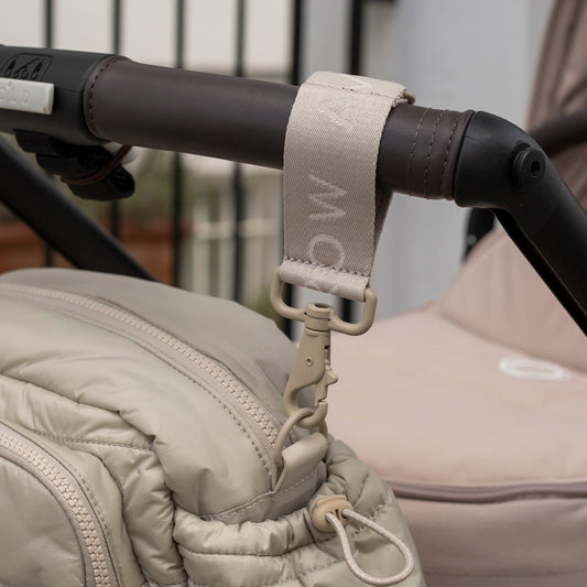 Close-up of a stroller handle with a strap, showing brand 'MamaWoo'.