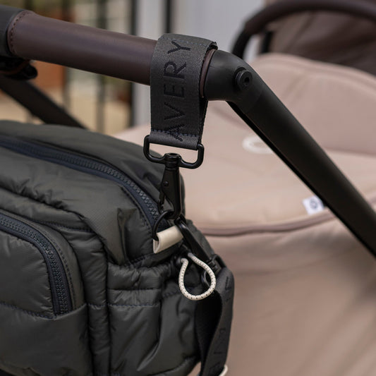 Black bag attached to a stroller with 'Nappy' label