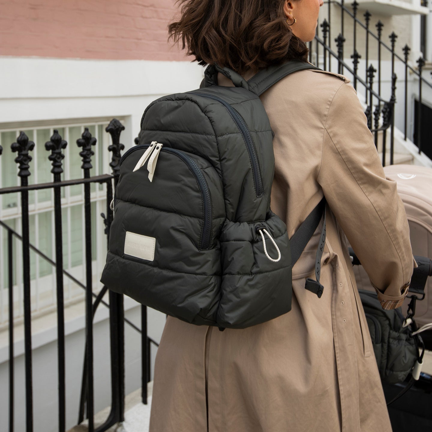 Person wearing a large black backpack on a balcony