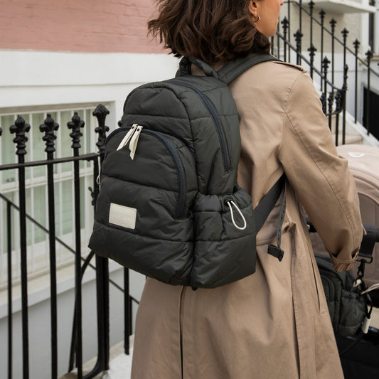 Person wearing a large black backpack on a balcony
