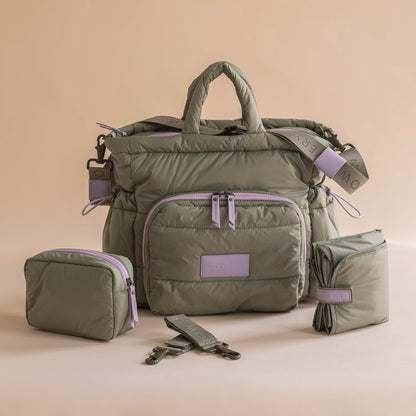 Green travel bag with purple accents on a beige background