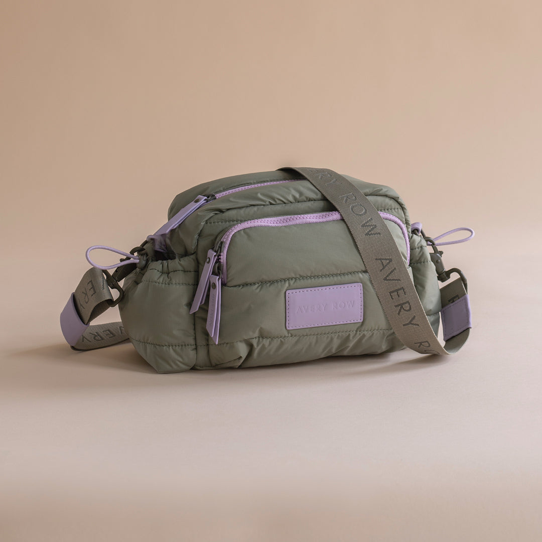 Green waist bag with purple accents on a beige background