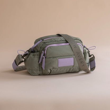 Green waist bag with purple accents on a beige background