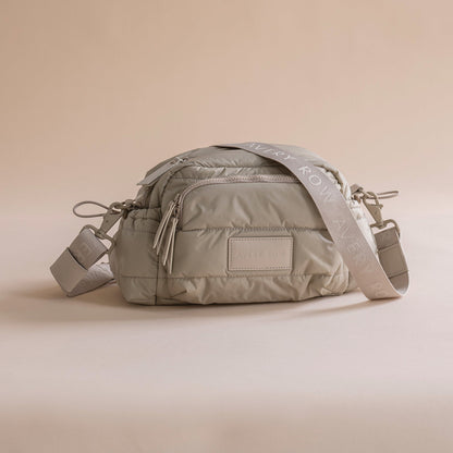 Gray quilted bag with a visible brand logo on a beige background