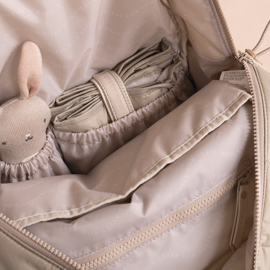 Baby blanket and toy inside a beige bag