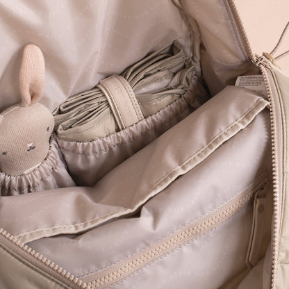 Baby blanket and toy inside a beige bag