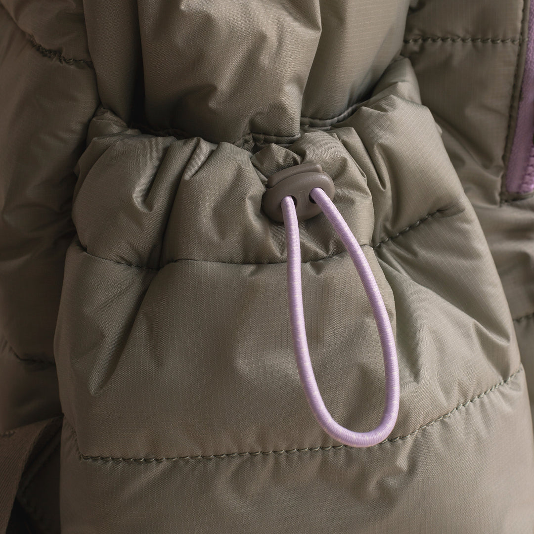 Close-up of a beige puffer jacket with a purple drawstring.