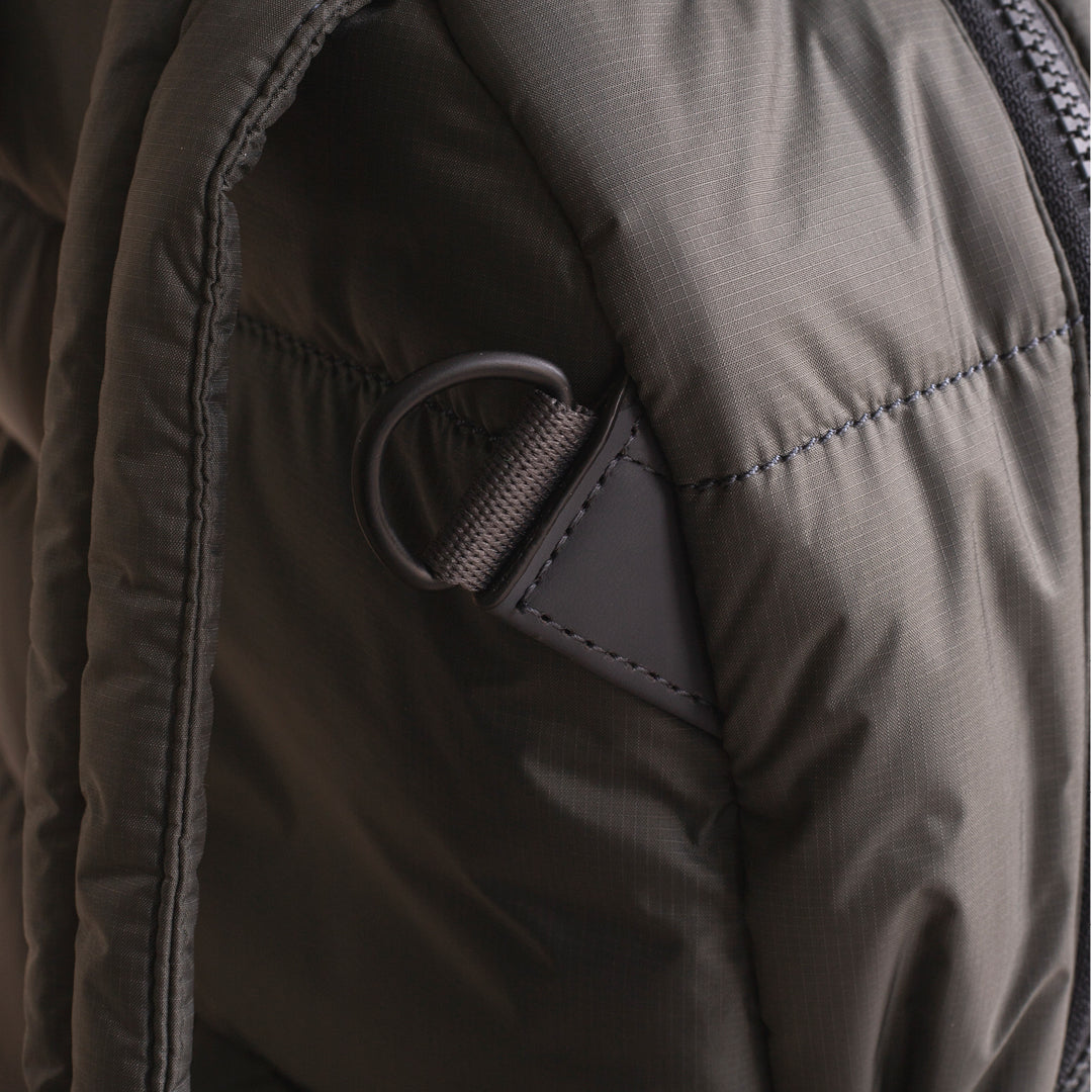 Close-up of a dark brown jacket with a zipper and button detail.