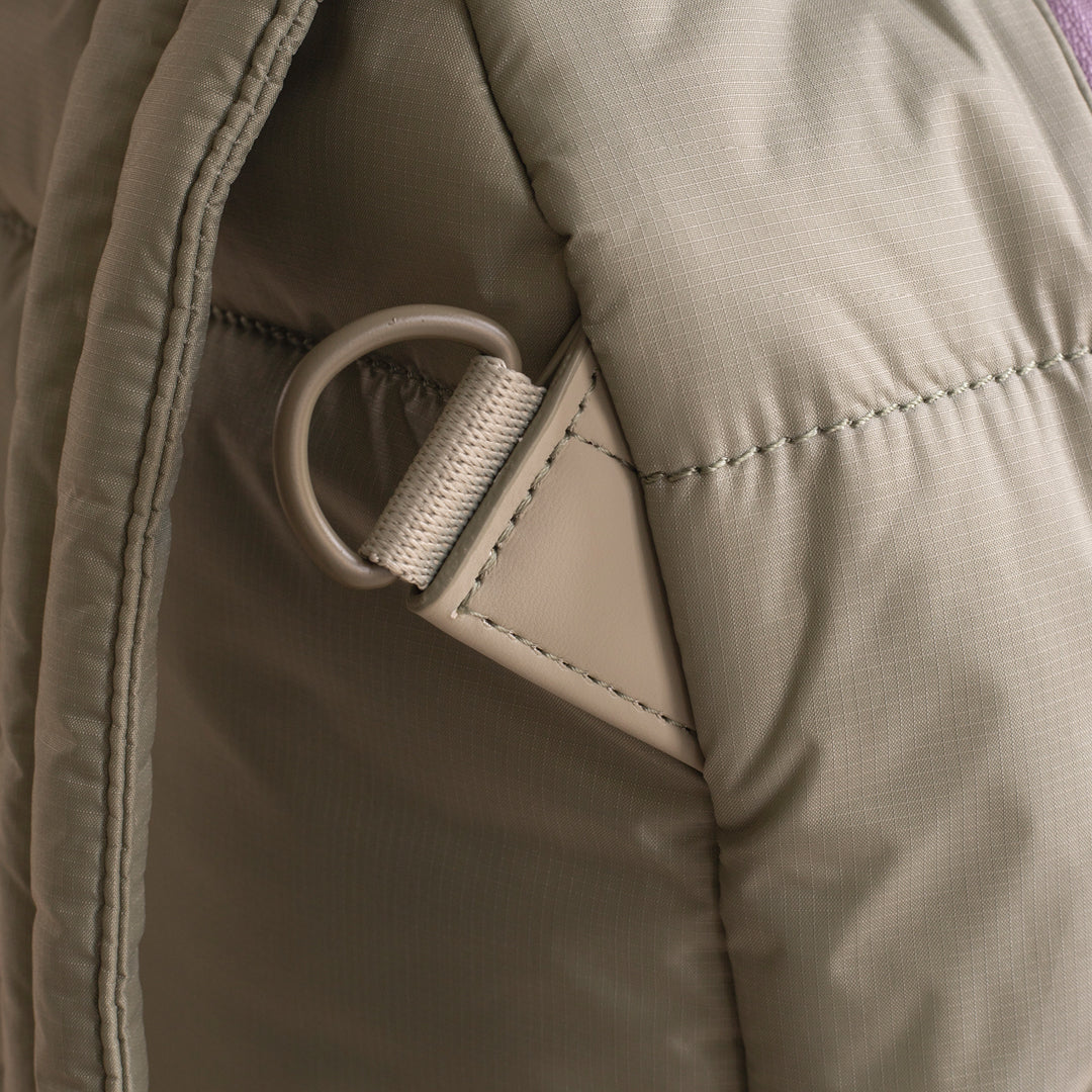 Close-up of a beige jacket with a zipper pull