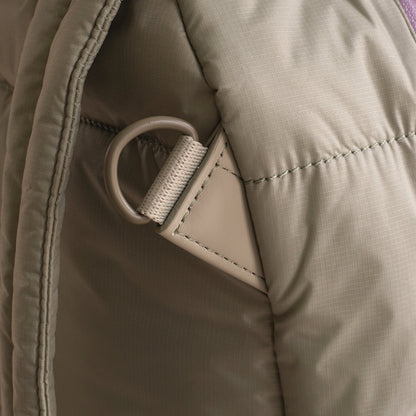 Close-up of a beige jacket with a zipper pull