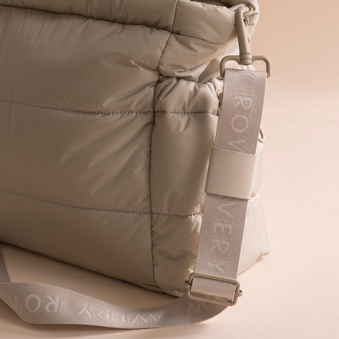Beige puffer jacket with a brand tag on a beige background