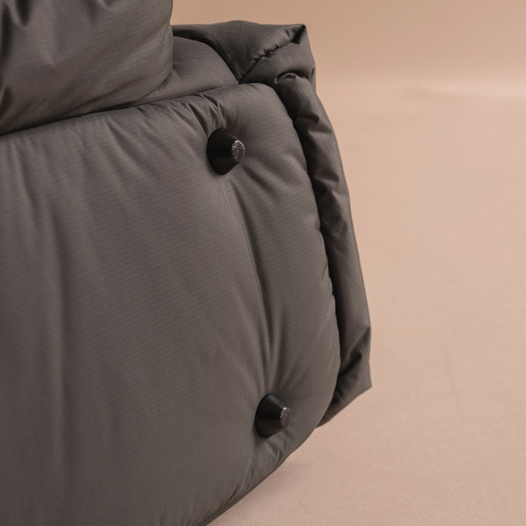 Close-up of a gray quilted jacket with buttons on a beige background