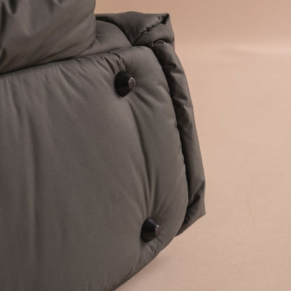 Close-up of a gray quilted jacket with buttons on a beige background