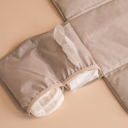 Folded beige quilt on a beige surface