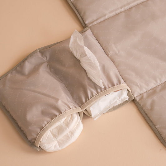 Folded beige quilt on a beige surface