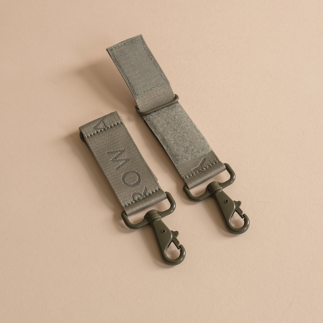 Two gray straps with metal hooks on a beige background