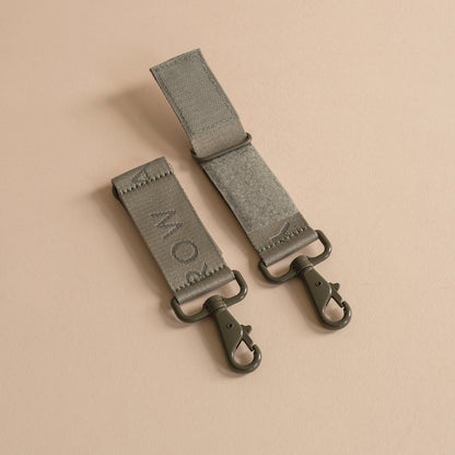 Two gray straps with metal hooks on a beige background